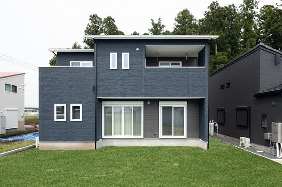 ネイビーと木目の外壁にホワイトのサッシで明るさをプラスした外観のお住まい