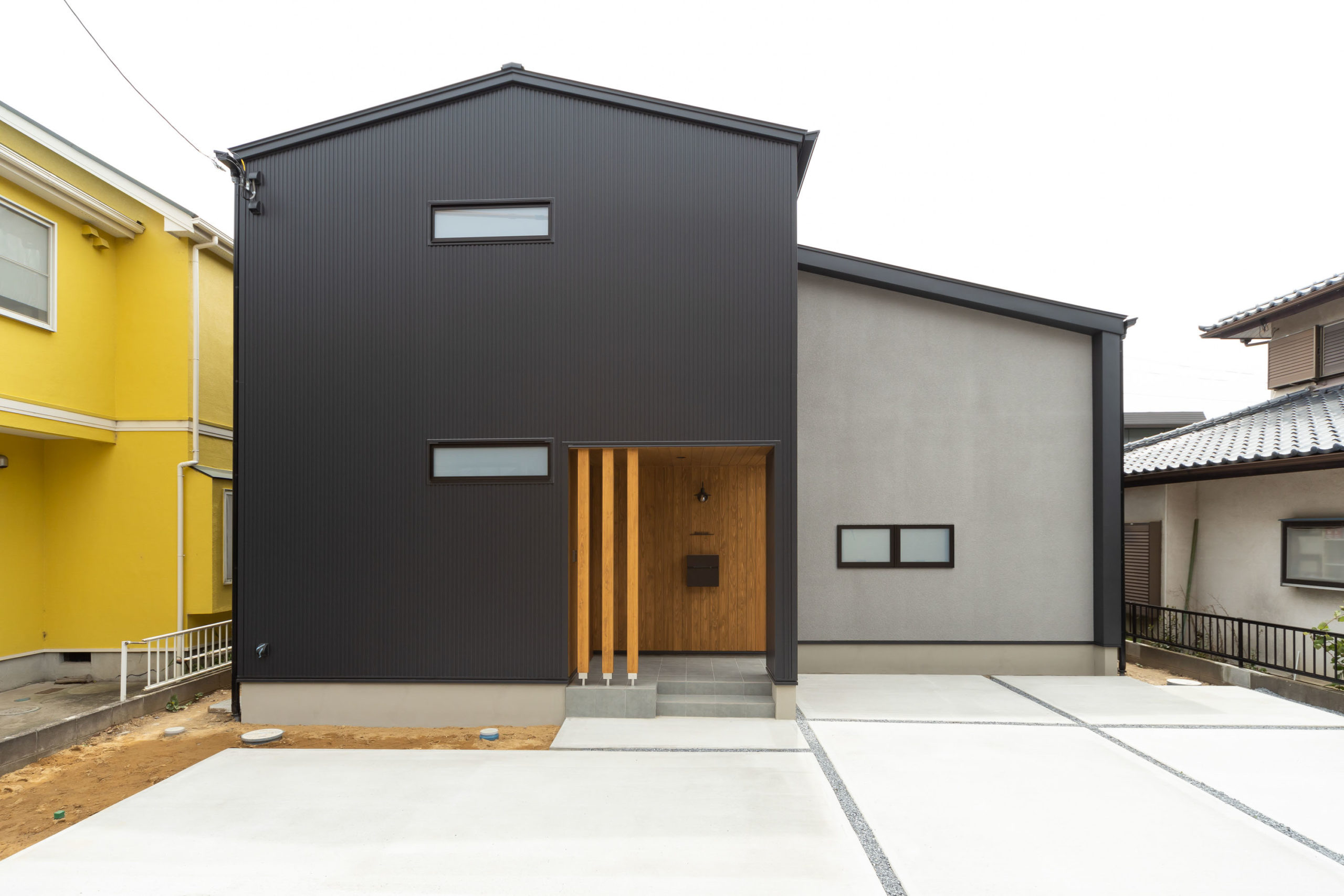 化粧梁とアイアン手すりがシンプルモダンな吹き抜けのある2階建て